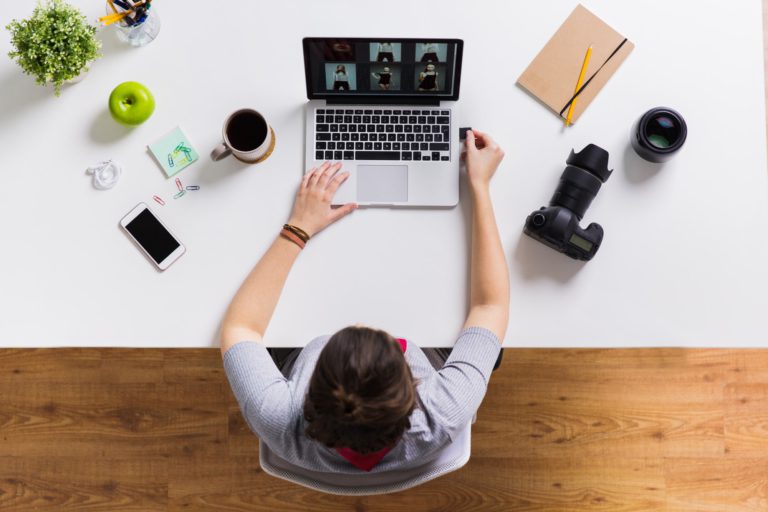 woman with camera flash drive and laptop at table